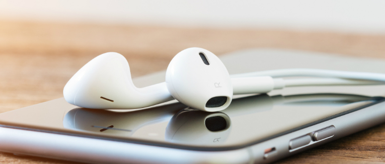 Headphones on top of a smartphone.
