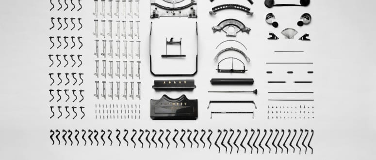 Parts of a disassembled typewriter in organized columns and rows.