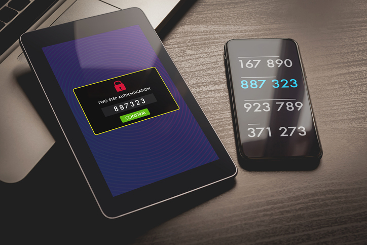 A tablet displays the text two step authentication. 887323. Confirm. A cell phone next to the tablet displays 8 three-number digits. 887 323 is highlighted.