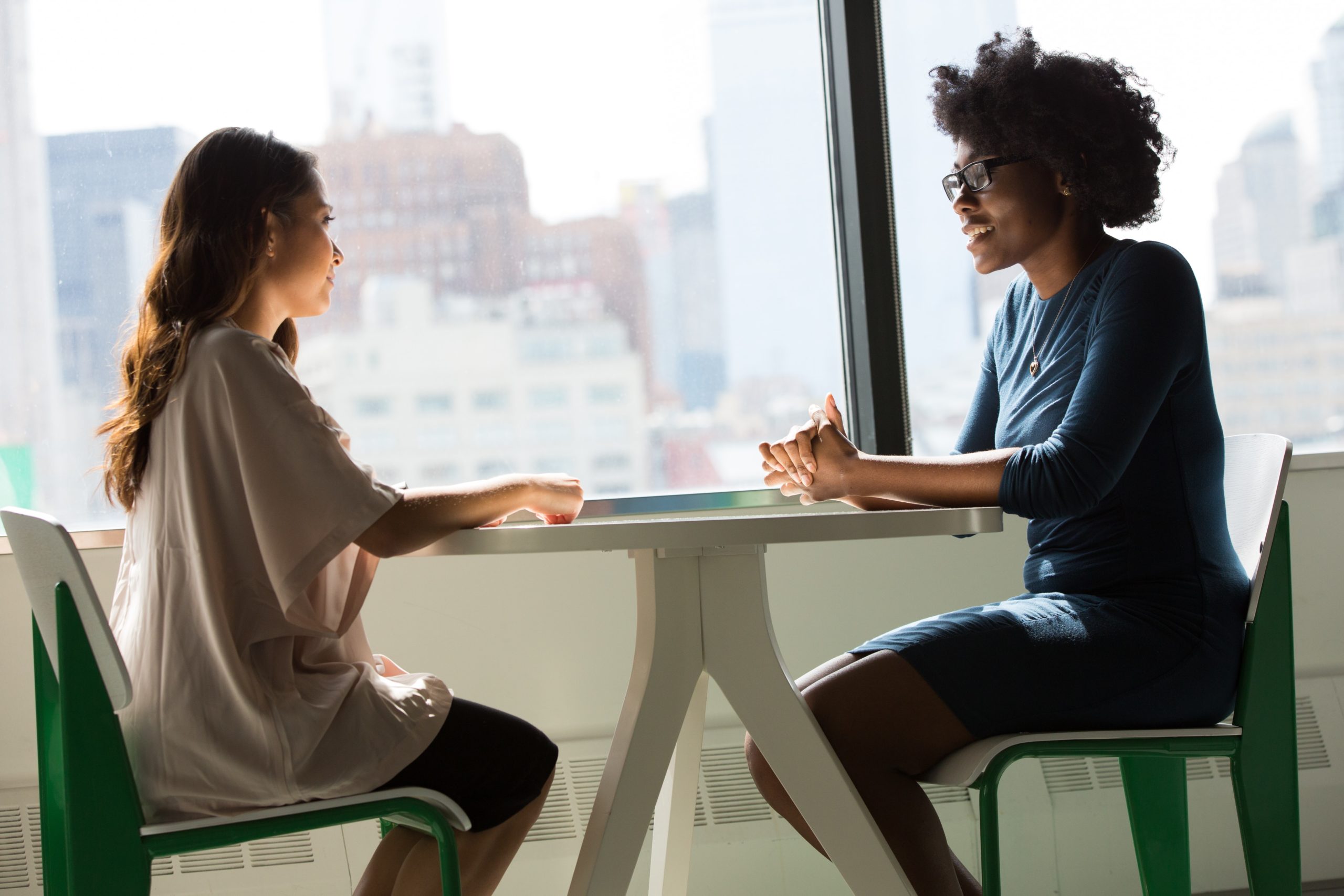 Two people sit at a table facing each other.