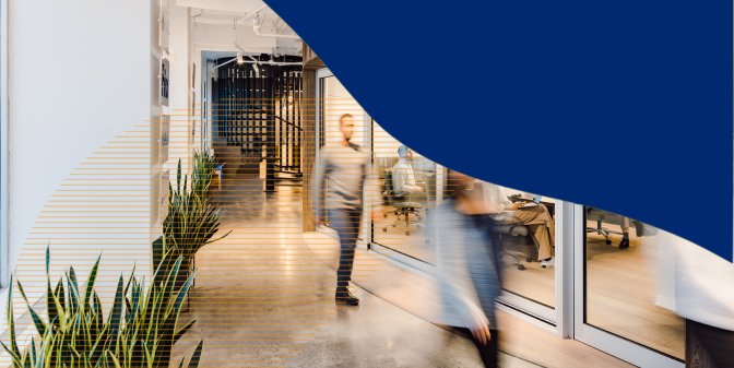 A well lit hallway with people walking in the hallway and showing the boardroom with abstract graphics on the photo