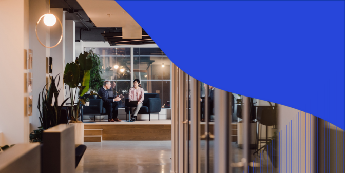 A photo of two co-workers talking on the chair on the stage with abstract design around the photo
